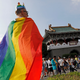 A participant is wrapped in a LGBT flag as he takes part in the pride parade in Taipei, October 28, 2017.